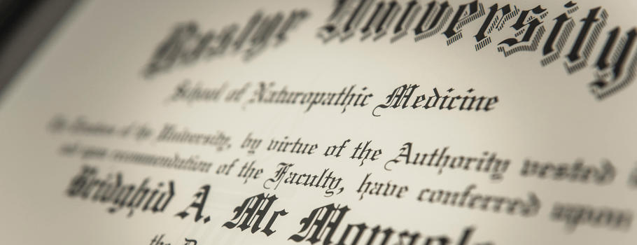 Close-up view of an elegant diploma certificate from a university, highlighting the institution's name, the school of anthropolytic medicine, and the recipient's name in formal script.