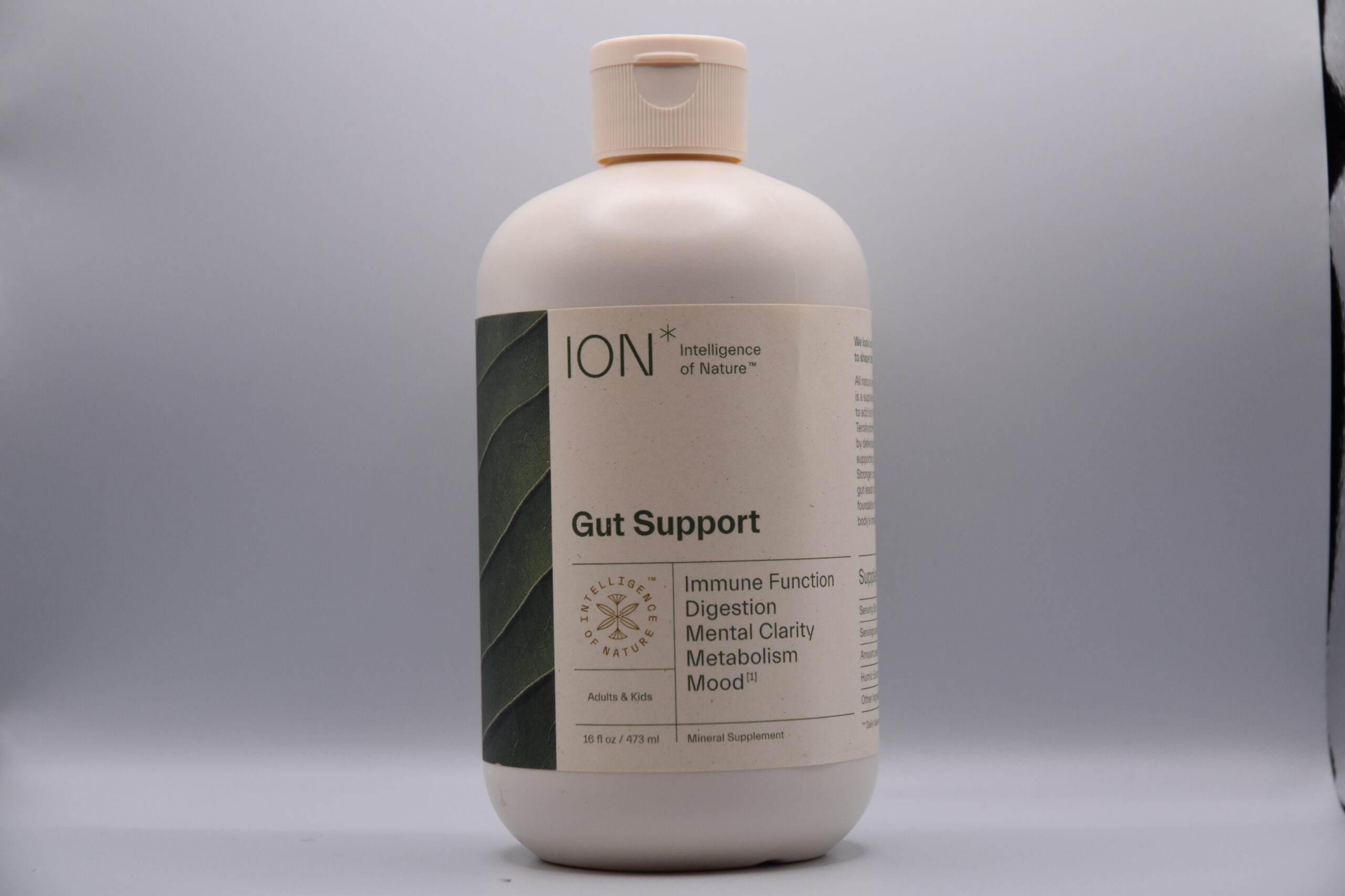 A bottle of Ion Gut Health / Restore - 8oz dietary supplement against a neutral background, advertising benefits for immune function, digestion, mental clarity, metabolism, and mood.