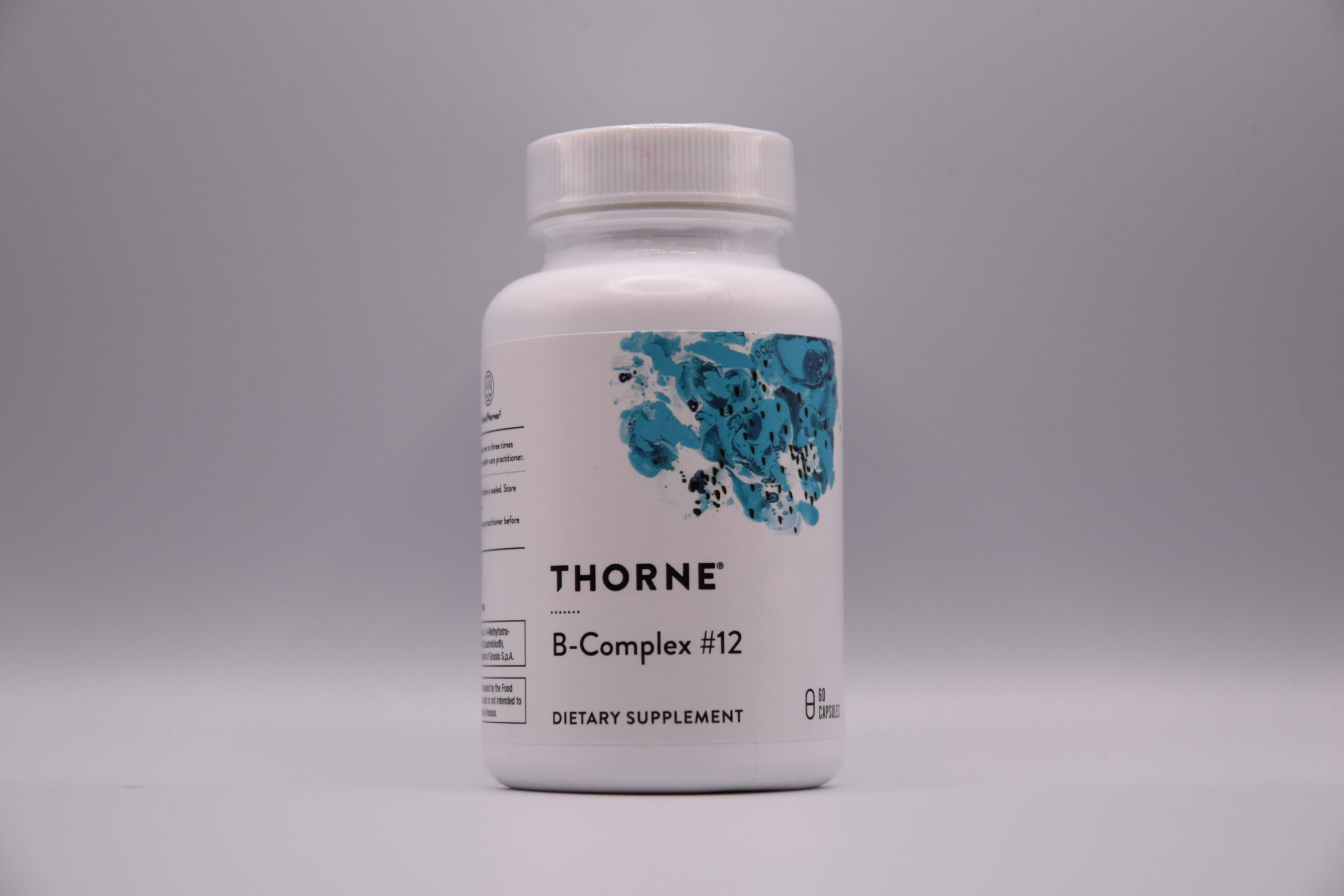 A bottle of Thorne - B-Complex #12 dietary supplement on a plain background.