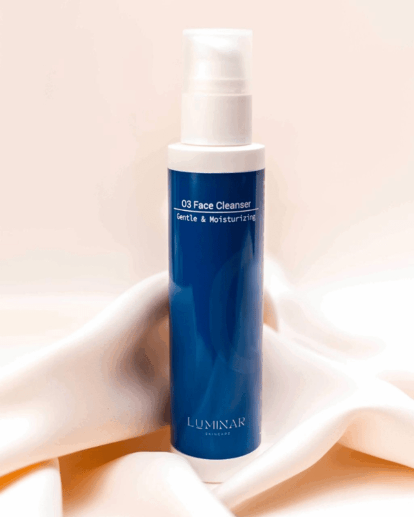 O3 Face Cleanser bottle placed on peachy silk fabric, evoking a fresh, gentle start to your skincare routine with a touch of elegance.