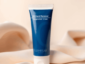 O3 Hand Renewal tube placed on peachy silk fabric, offering a soft and soothing visual that reflects gentle hand care and renewal