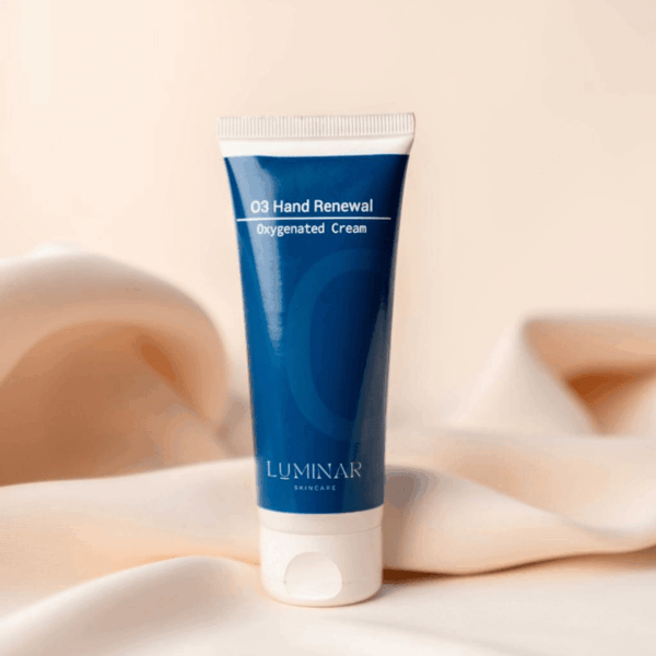 O3 Hand Renewal tube placed on peachy silk fabric, offering a soft and soothing visual that reflects gentle hand care and renewal