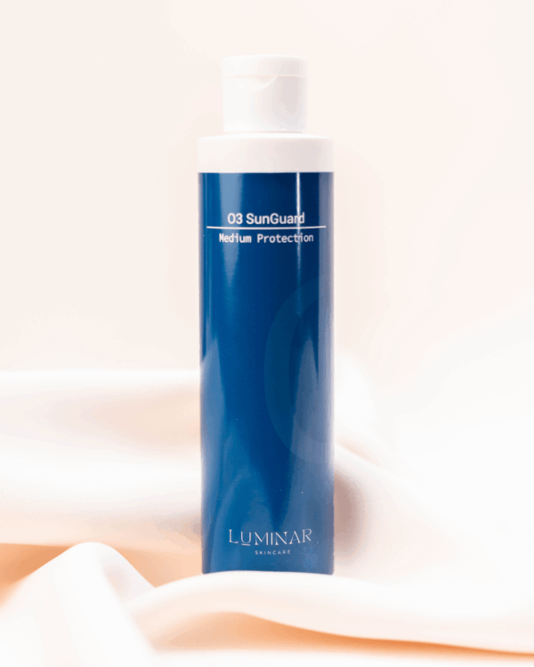 O3 Sunguard bottle resting on peachy silk fabric, combining sun protection with a soft, elegant aesthetic.