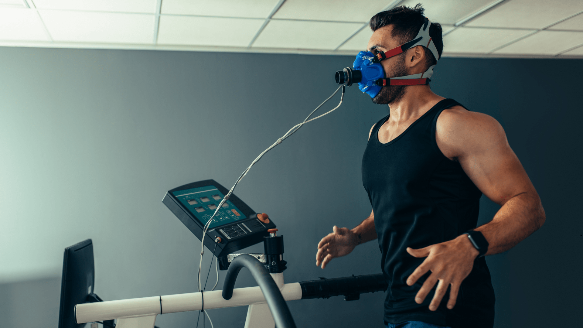 Man running on a treadmill wearing a PNOE metabolic testing mask, measuring oxygen consumption, heart performance, and metabolic efficiency during exercise.