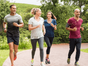 Group of adults jogging together outdoors in a park setting.
