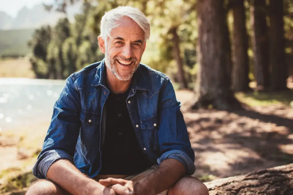 Smiling older man enjoying time outdoors, representing healthy aging and longevity.