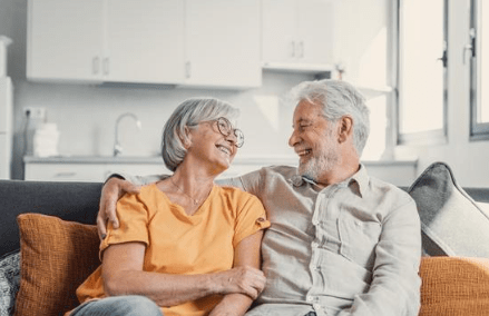 Elderly couple sitting on a couch energized and revitalized.