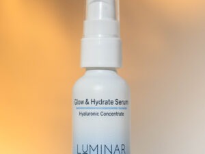 The Glow & Hydrate serum standing elegantly against a warm background.