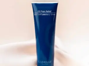 The O3 Pain relief bottle against a warm background and on top of a luxurious silk.
